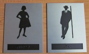 Restroom signs with classy woman and classy man leaning against wall